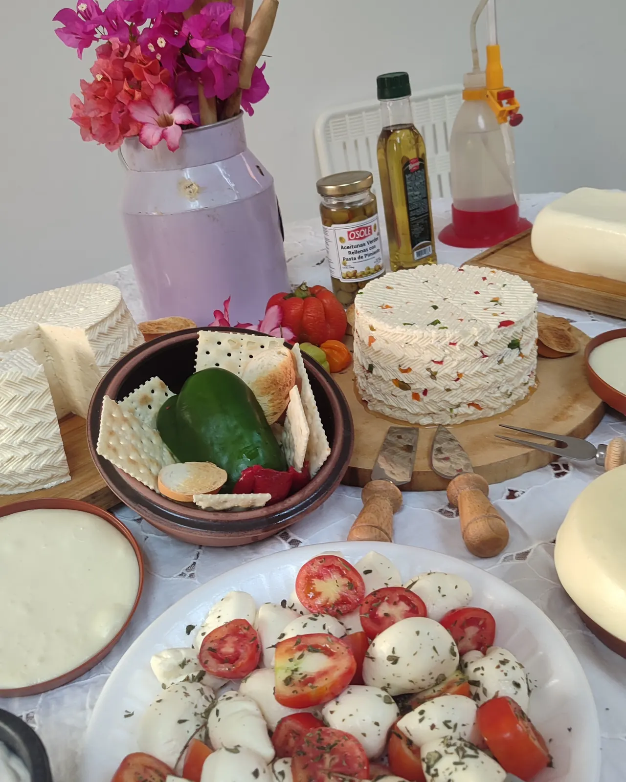 Mesa de degustación con quesos frescos, queso aliñado y botellas de aceite